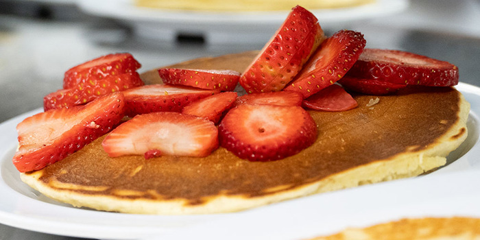 Pancake topped with strawberries off the griddle at the Place in Glendale, AZ